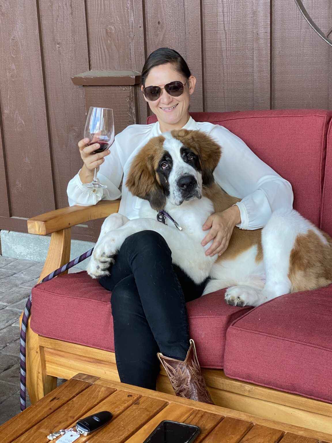 woman tasting wine with St. Bernard dog