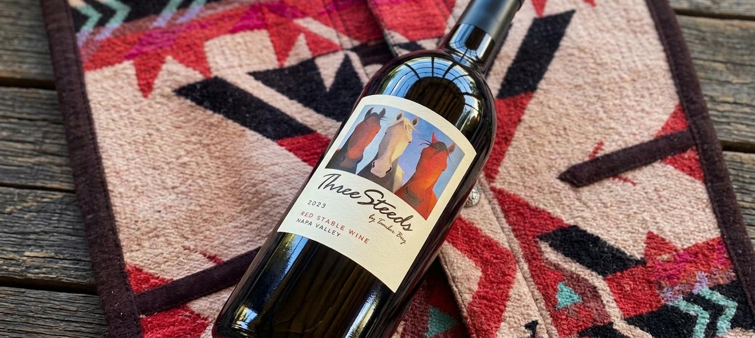 A bottle of 2023 Three Steeds Red Stable Wine on a wool blanket at the ranch.
